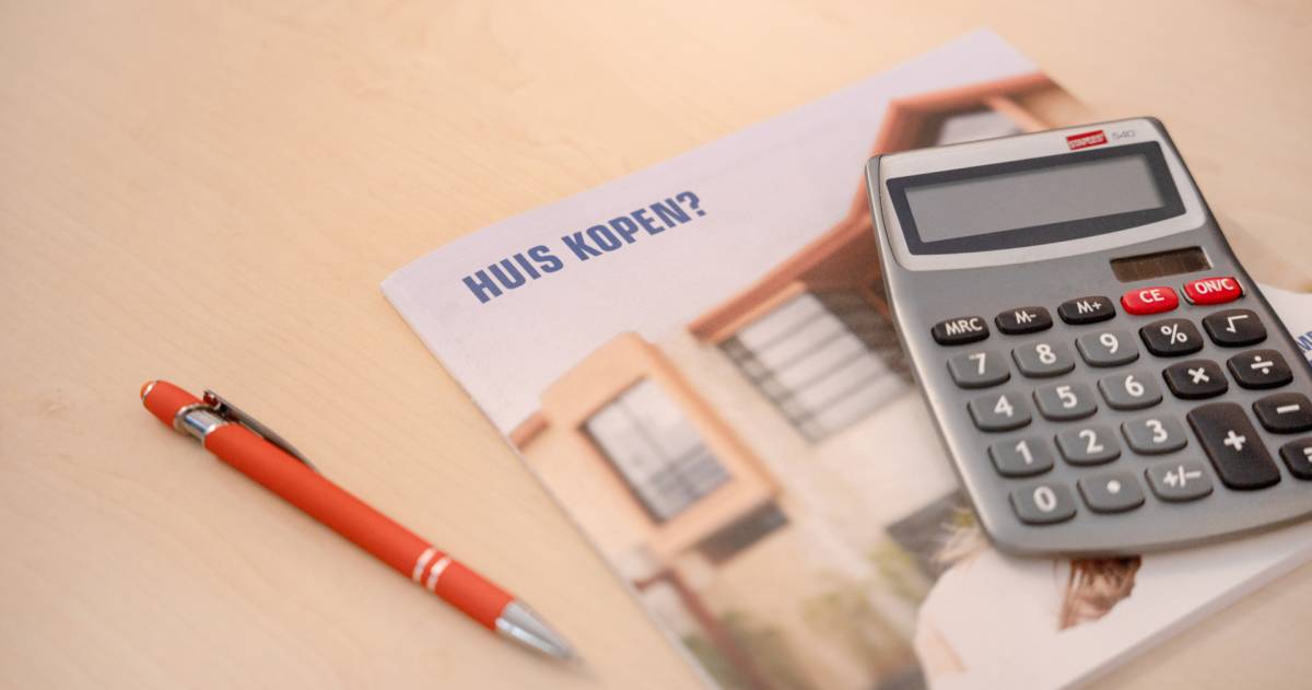 Een brochure over het kopen van een huis met daarbovenop een rekenmachine en ernaast ligt een pen