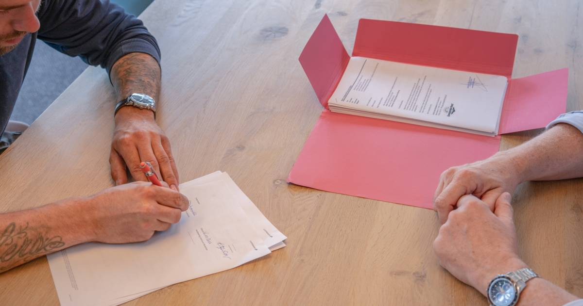 Een klant ondertekend papieren samen met de adviseur